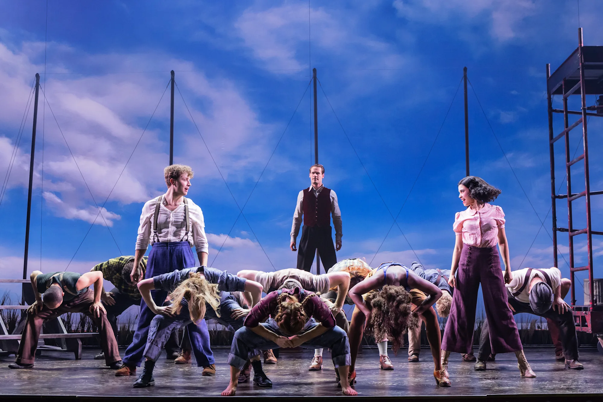 Zachary Keller, Connor Sullivan, Helen Krushinski, and the cast of WATER FOR ELEPHANTS is arranged in a dance routine with most people with their hands on knees and heads bowed low. Photo by Matthew Murphy for MurphyMade