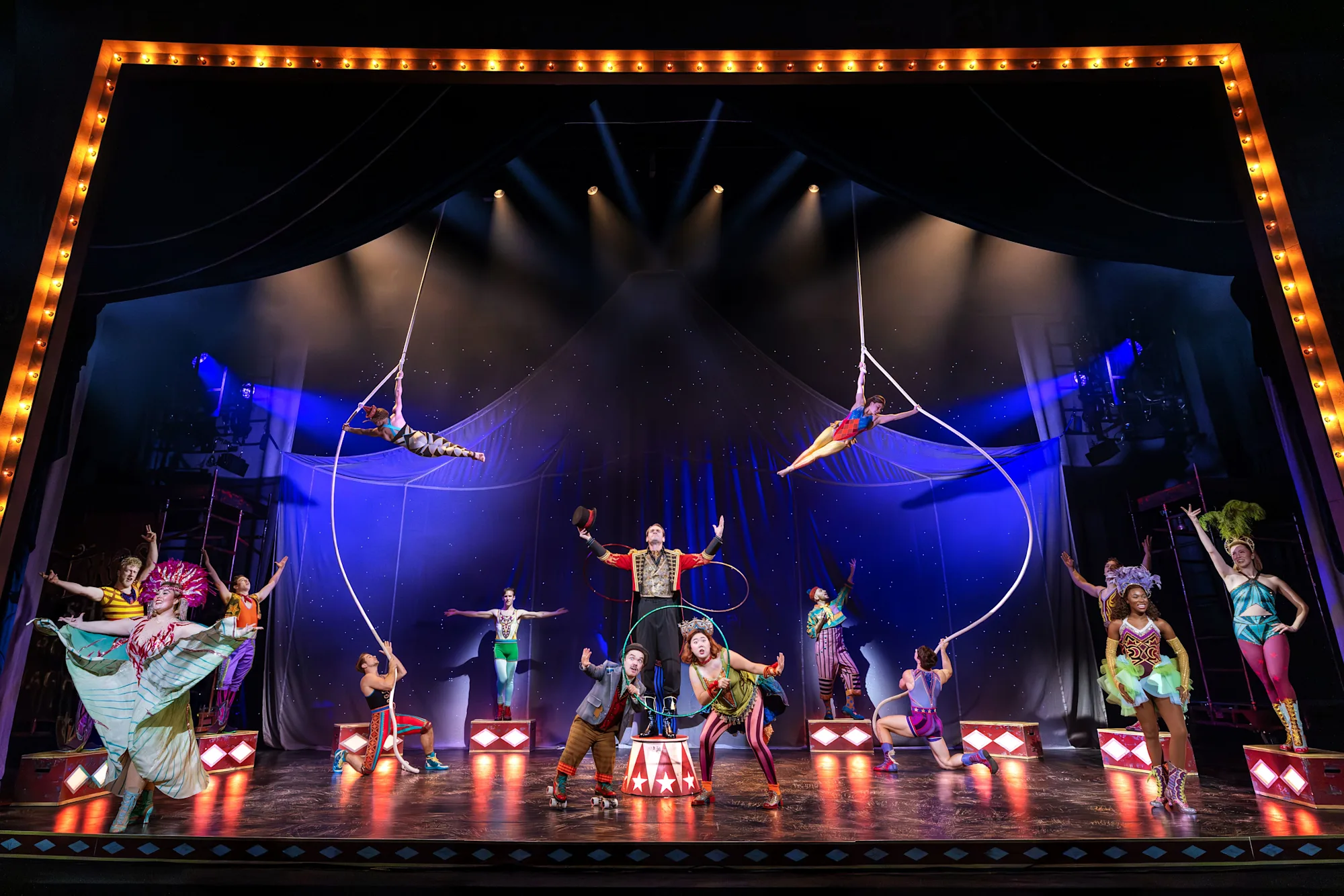 The cast of WATER FOR ELEPHANTS is assmbled in a one large ring with people doing different poses and acrobatics. Photo by Matthew Murphy for MurphyMade