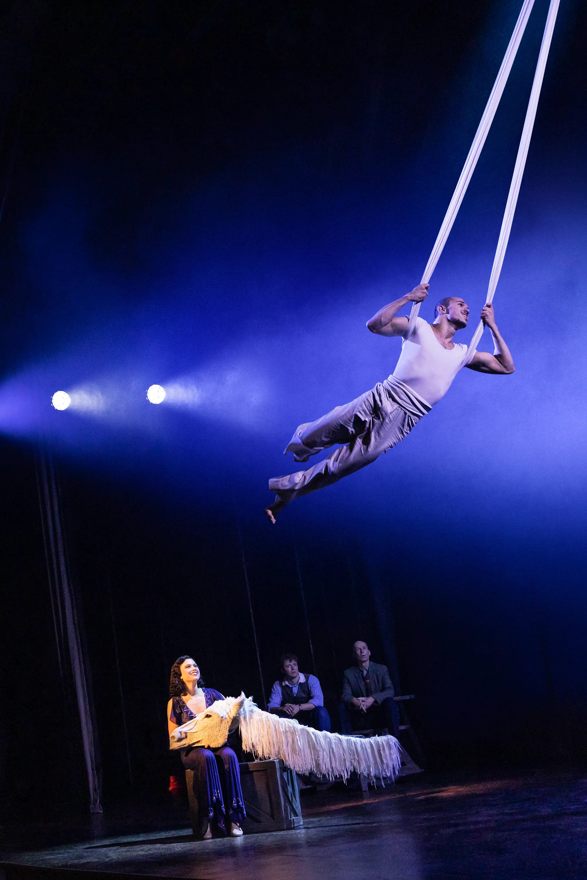 Helen Krushinski, Robert Tully, Zachary Keller, and Yves Artieres. Three people watch another person swinging from ropes high above their heads. Photo by Matthew Murphy for MurphyMade