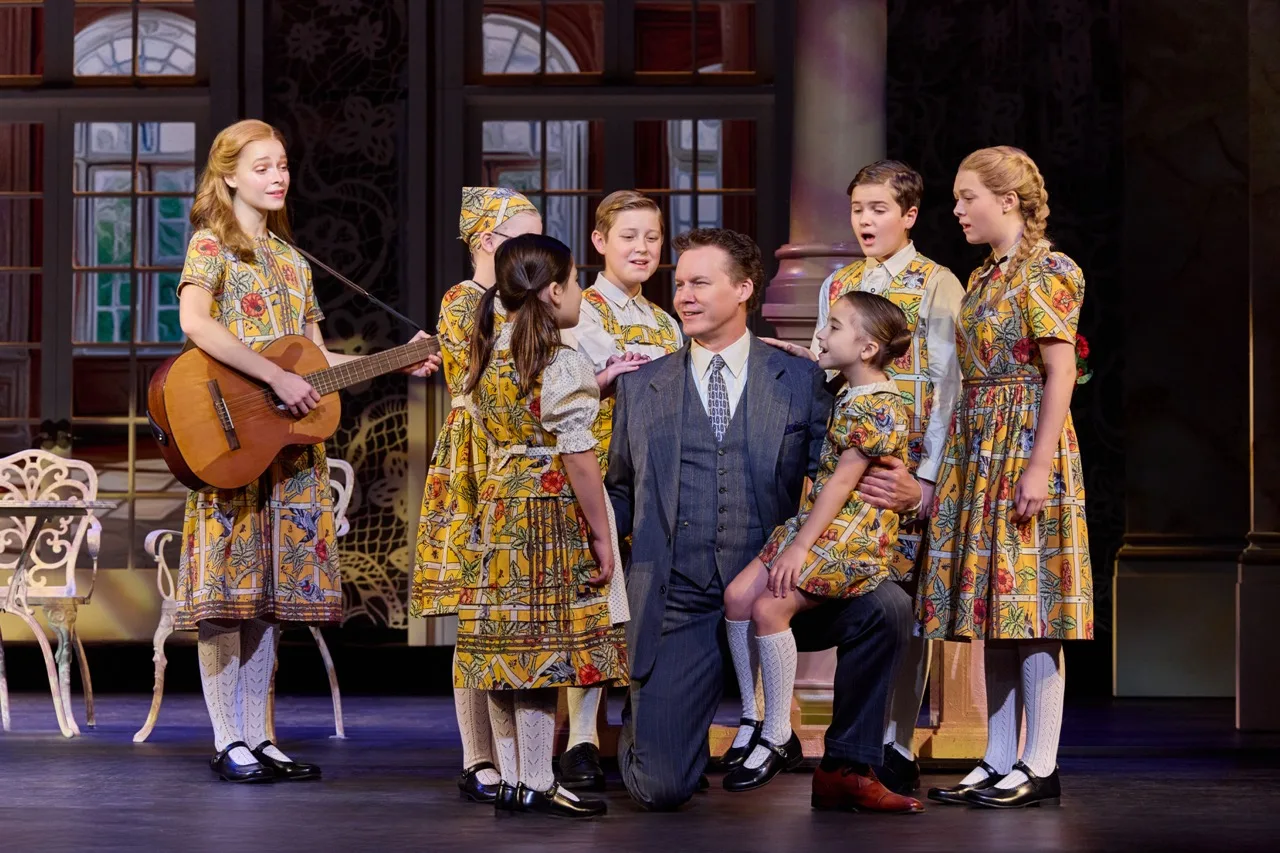 (center) Kevin Earley (Captain Georg von Trapp) with the von Trapp Children (l to r) Ariana Ferch (Liesl), Haddie Mac (Brigitta), Ruby Caramore (Marta), Benjamin Stasiek (Kurt), Luciana VanDette (Gretl), Eli Vander Griend (Friedrich), Ava Davis (Louisa) in The Sound of Music. Photo by Jeremy Daniel.
