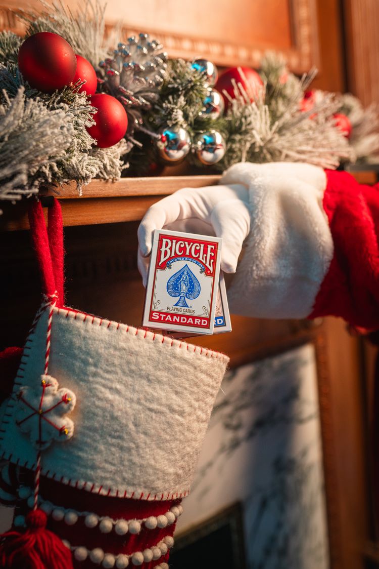 santa hand placing decks of playing cards into stocking