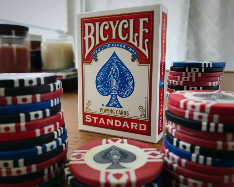 Pack of cards standing in the middle of some poker chips