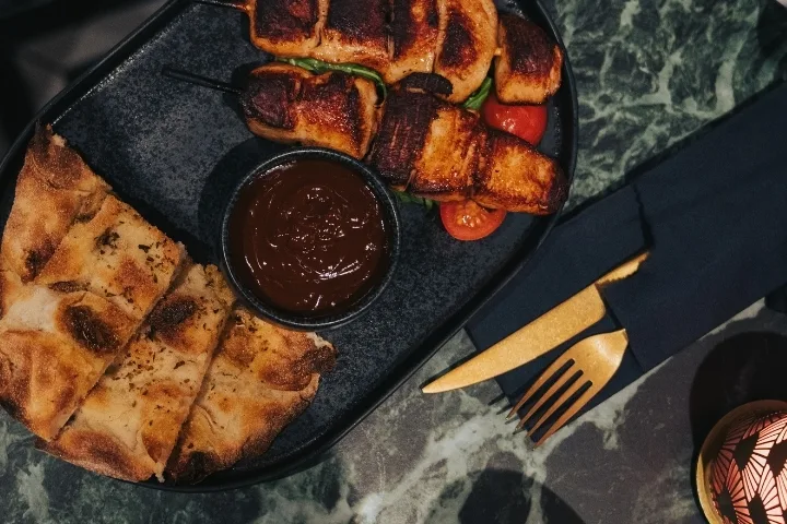 Goldenes Besteck mit Essen auf schwarzen Tellern