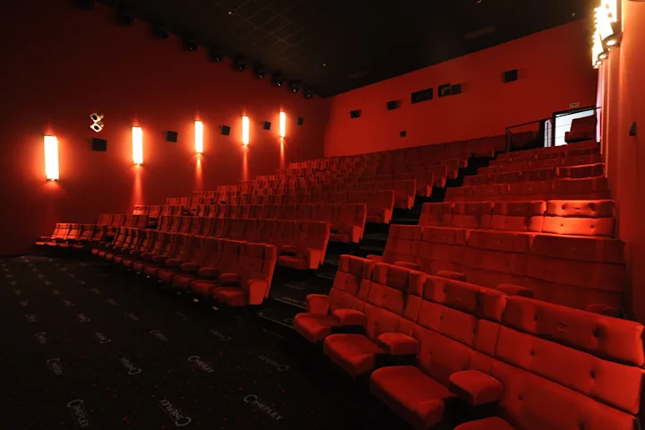 Foto, das einen Kinosaal des Cineplex Neufahrn zeigt - darauf zu sehen sind rote Kinosessel.