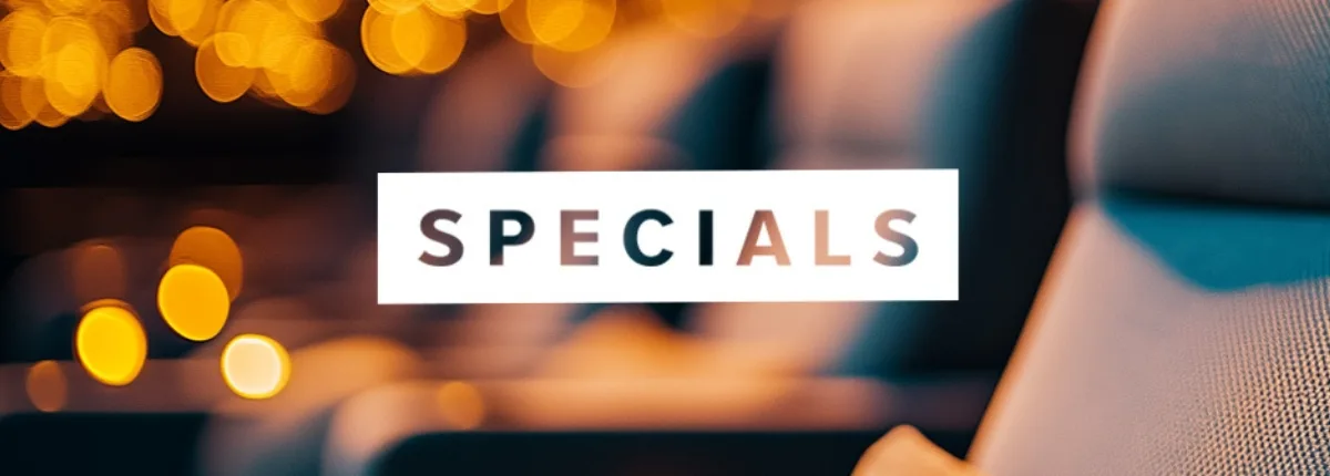 Banner mit dem Wort „SPECIALS“ in weißer Schrift vor unscharfem Hintergrund aus Kino- oder Eventbeleuchtung. Warme gelbe Lichtpunkte und Sitzreihen erzeugen eine stimmungsvolle, edle Atmosphäre.