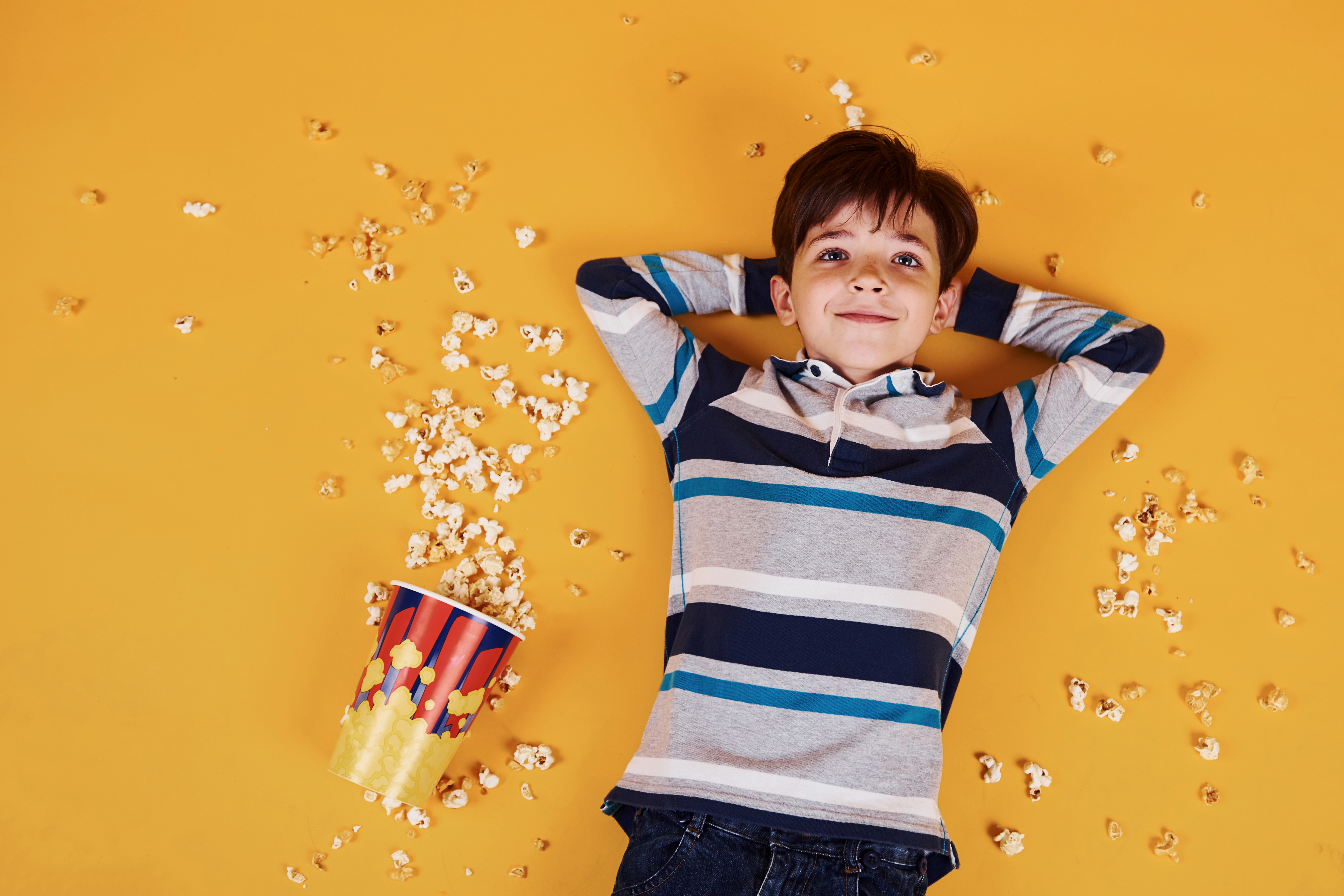 Junge liegt inmitten von Popcorn