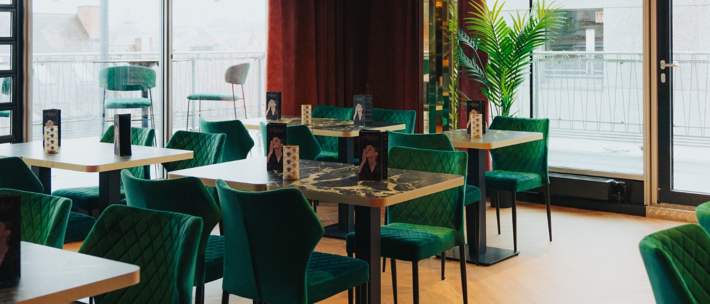 Die Sky Bar mit grüner Samtbestuhlung und Sicht auf die Dachterasse