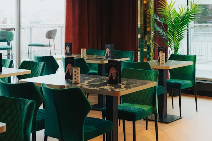 Die Sky Bar mit grüner Samtbestuhlung und Sicht auf die Dachterasse