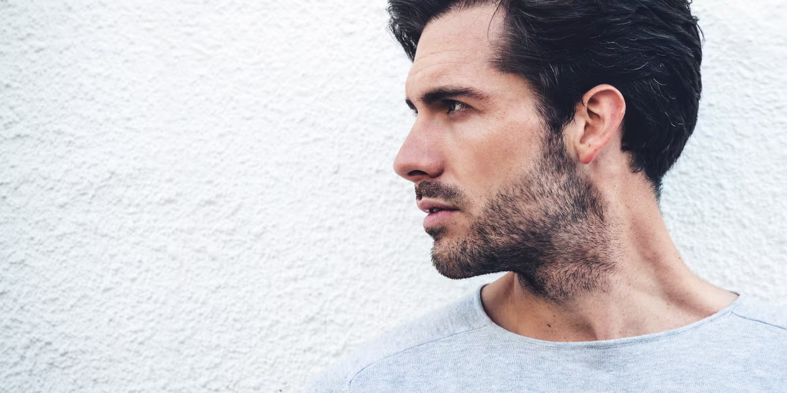 Side profile of a man with a stubble beard.