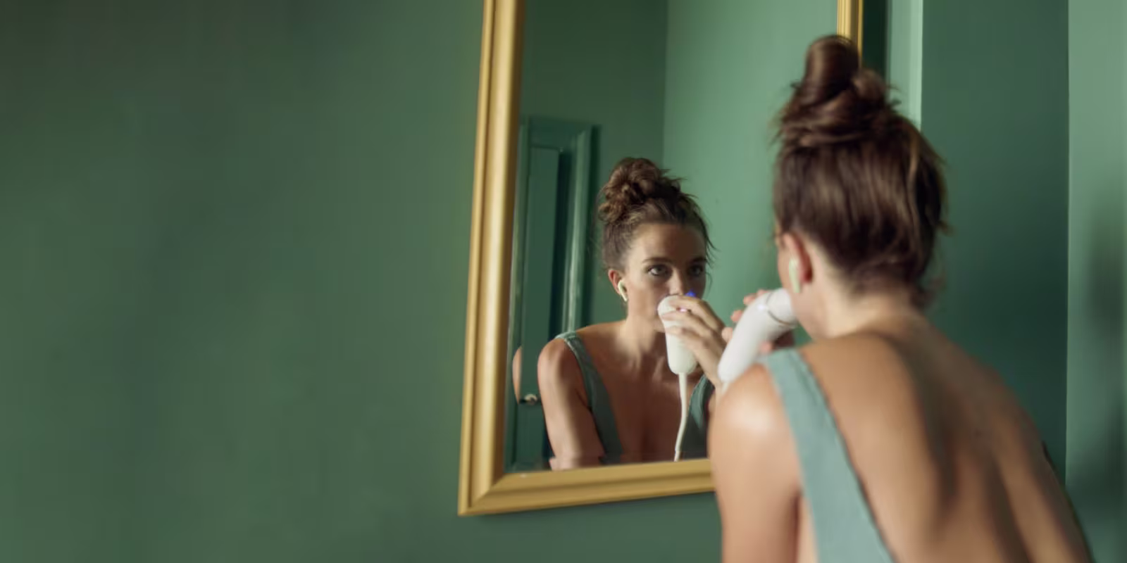Woman using a Braun IPL device to remove her facial hair.