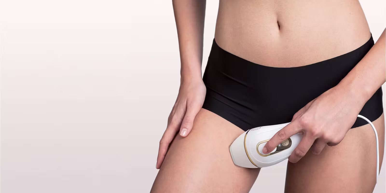 Person using a Braun IPL device to remove hair in the area between the legs. Person using a Braun IPL device to remove hair in the area between the legs.
