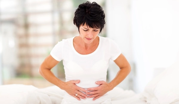 Женщина испытывает дискомфорт в животе