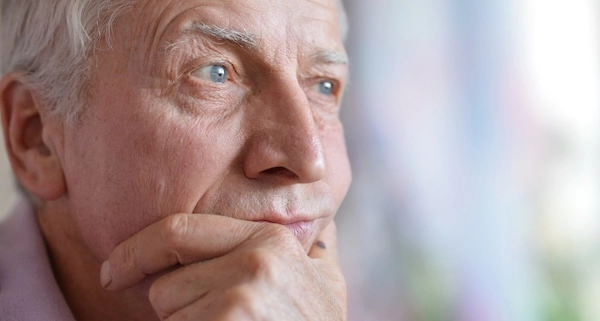Мужчина пожилого возраста Пожилой мужчина держит руку у лица