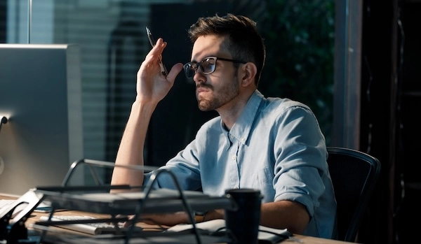 Мужчина с плохим зрением смотрит в монитор Мужчина в очках смотрит в монитор