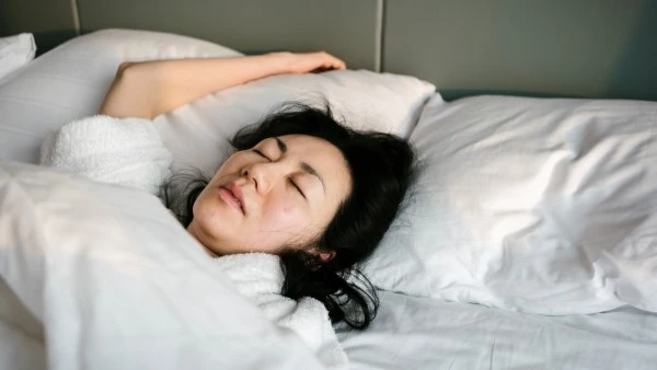 Девушка лежит в постели при воспалительном заболевании кишечника