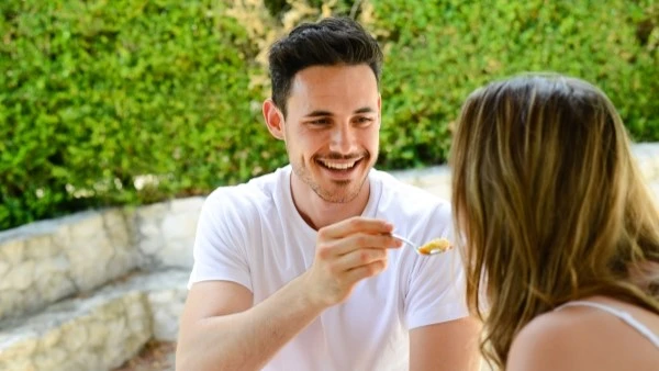 Мужчина кормит девушку едой с ложки