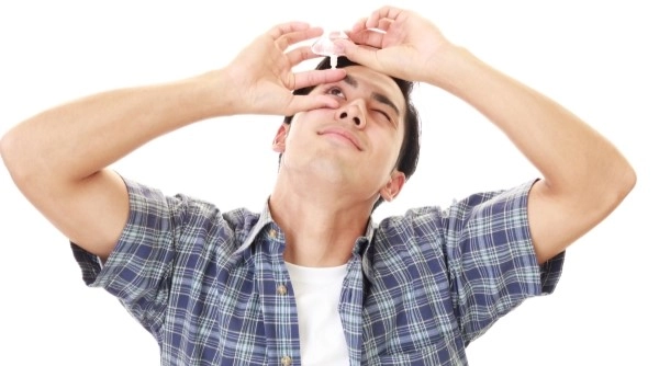 Мужчина использует капли для лечения глаз