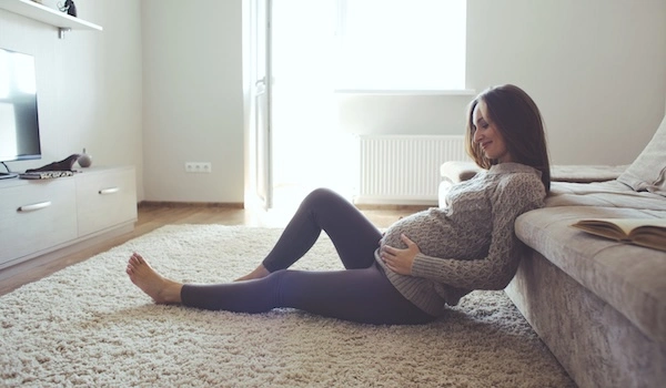 Беременная женщина трогает живот