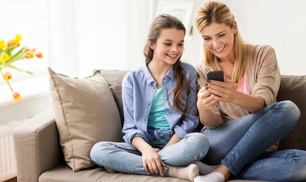 Перед применением глазных капель ознакомьтесь с инструкцией Мама и дочь изучают информацию на смартфоне