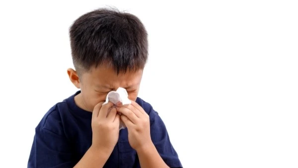 Мальчик сморкается в носовой платок