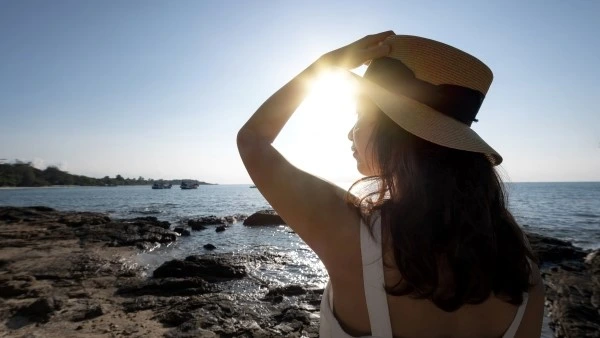 Усиление ломкости волос под действием солнечного света Девушка сидит на море под солнцем