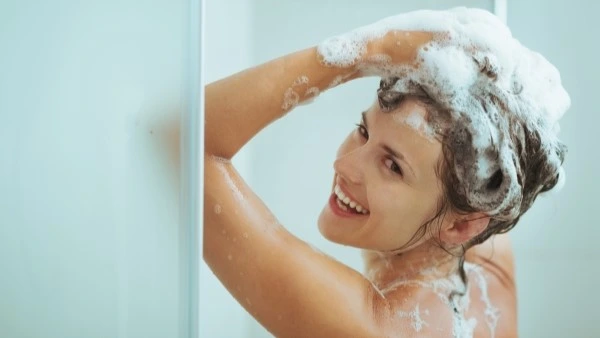 Девушка моет волосы в душе