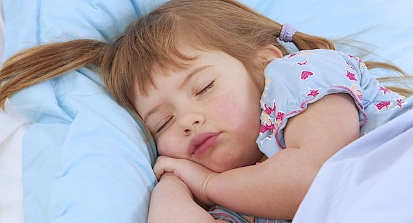 Ребенок спит в кровати