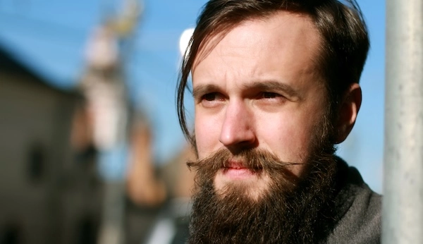 Мужчина слегка прищуривается