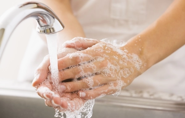 Намыленные руки и кран крупным планом