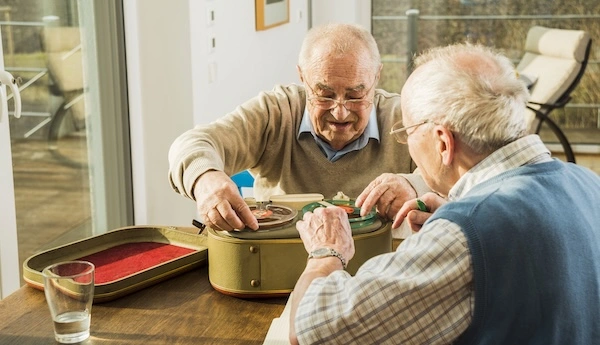 Мужчины старческого возраста сидят за столом