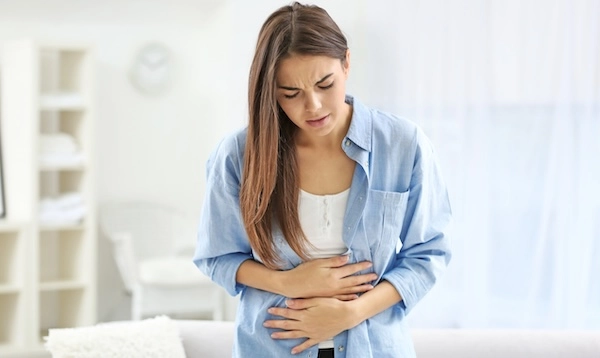 Девушка прикасается руками к животу