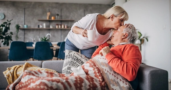 Женщина подает чай мужчине с температурой