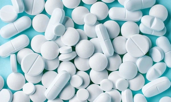 Белые таблетки на голубом столе