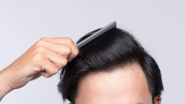 Мужчина расчёсывает волосы