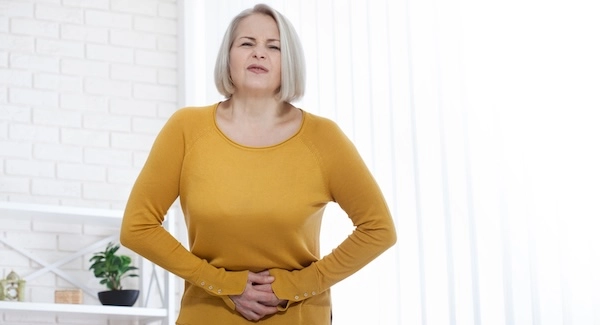 Каловые камни могут вызывать боль в животе Женщина в возрасте с признаками боли в животе