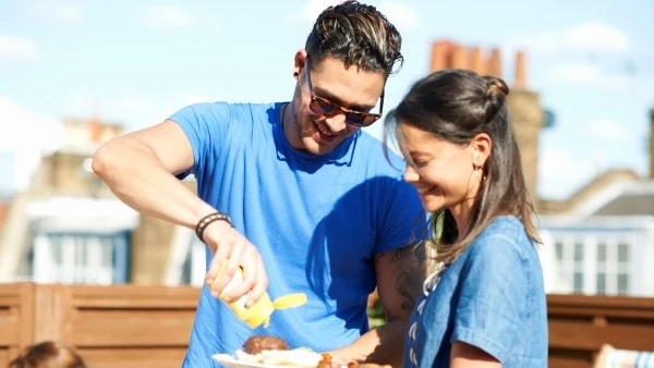 Мужчина рядом с девушкой поливает котлету соусом