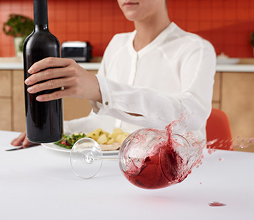 Red wine spilling onto a white table