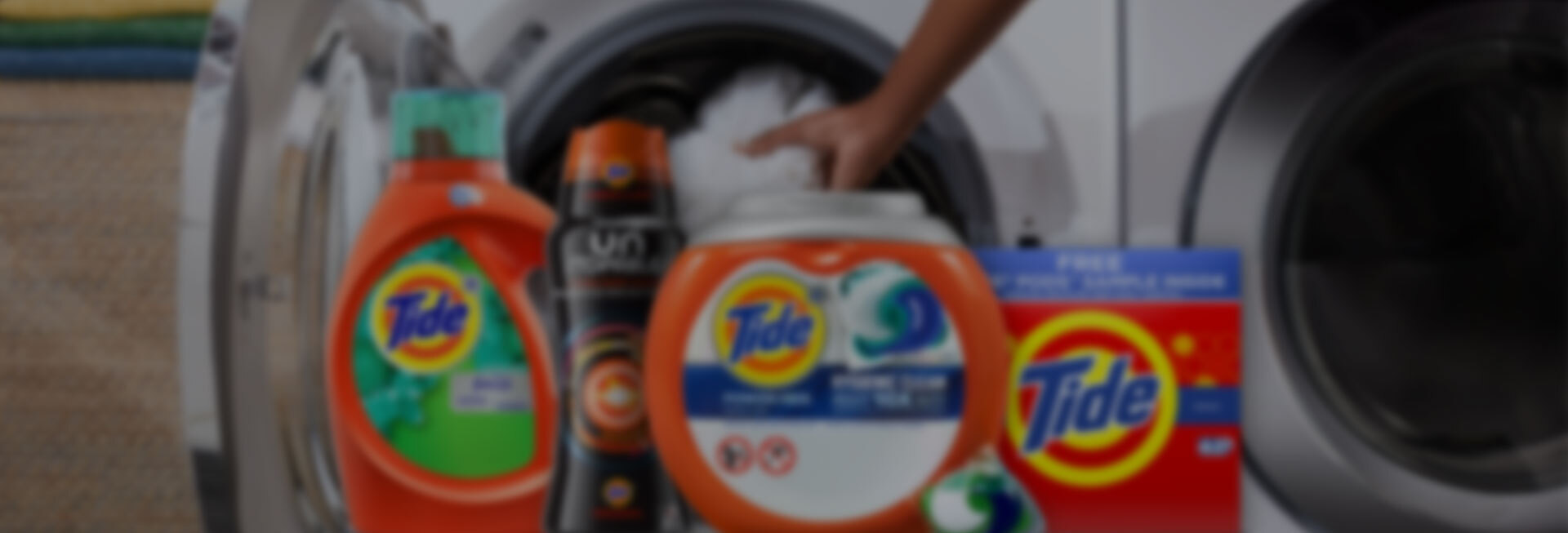 Various Tide products in front of a washer