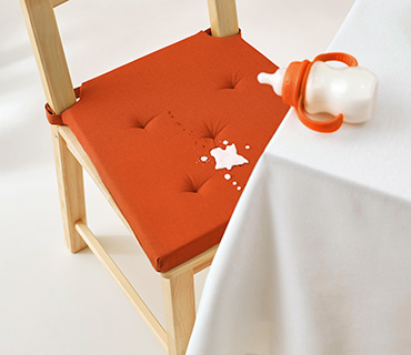 Baby formula stains on an orange chair cover