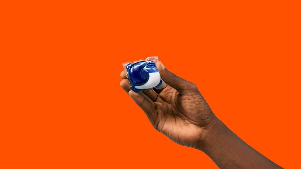 A person holding one Tide PODS washing capsule