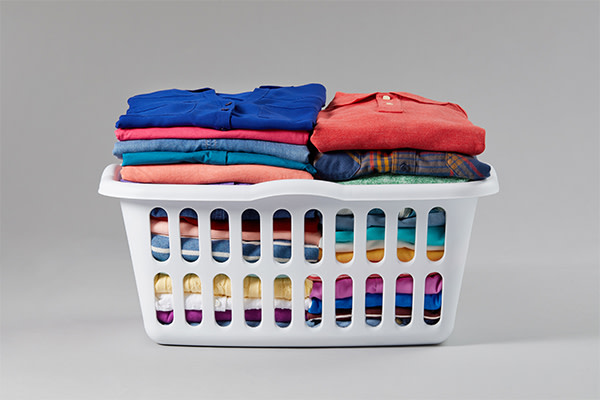 A laundry basket full of neatly folded, colorful gaments