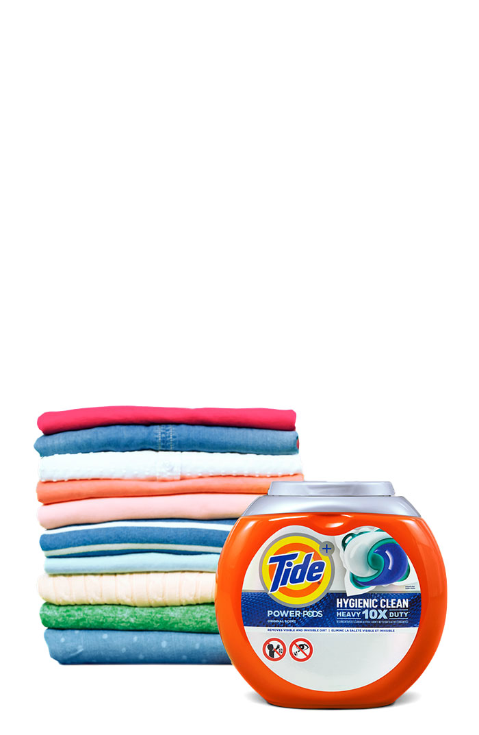 Tide Hygienic Clean Heavy Duty 10x Power PODS in front of a pile of folded colorful clothes