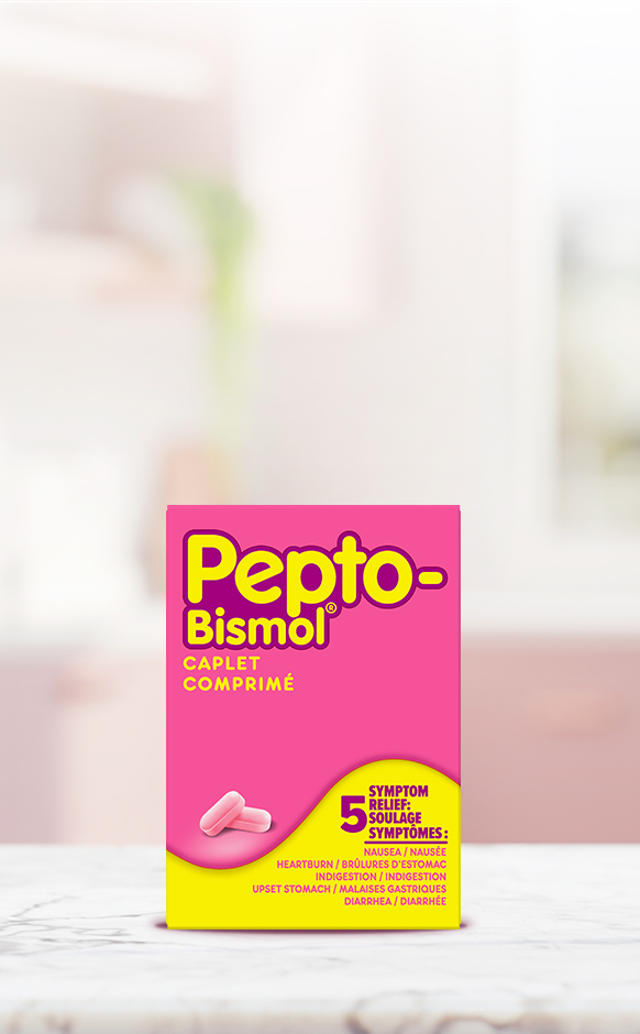 Pink and yellow Pepto-Bismol Caplet box for 5-symptom relief, displayed on a white surface with a blurred background.