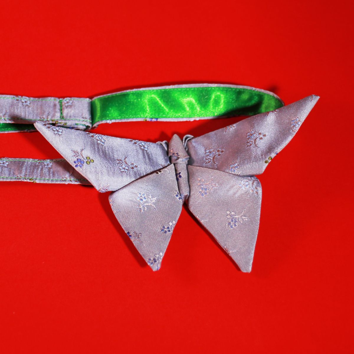 An origami butterfly bow tie with satin ribbon exposed