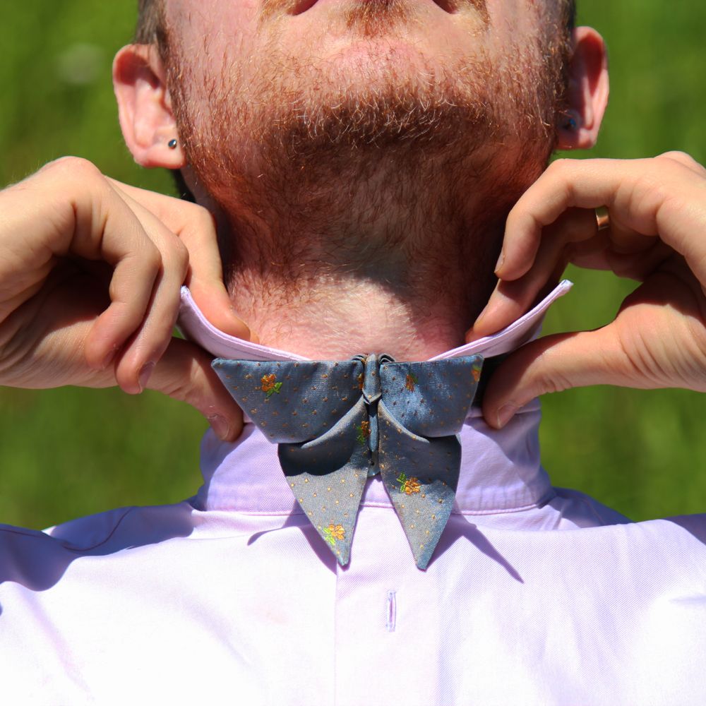 Man Putting on an origami inspired butterfly bow tie