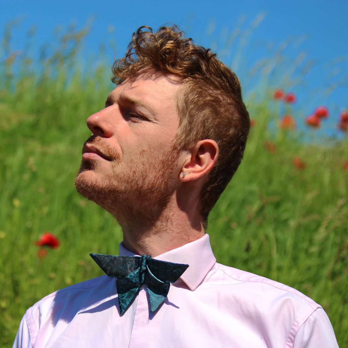 Man wearing an origami bow tie with light blue floral pattern 