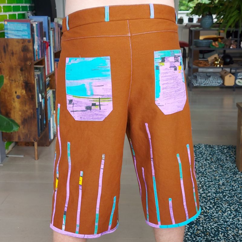 Brown shorts with colourful decorative details and deep pockets