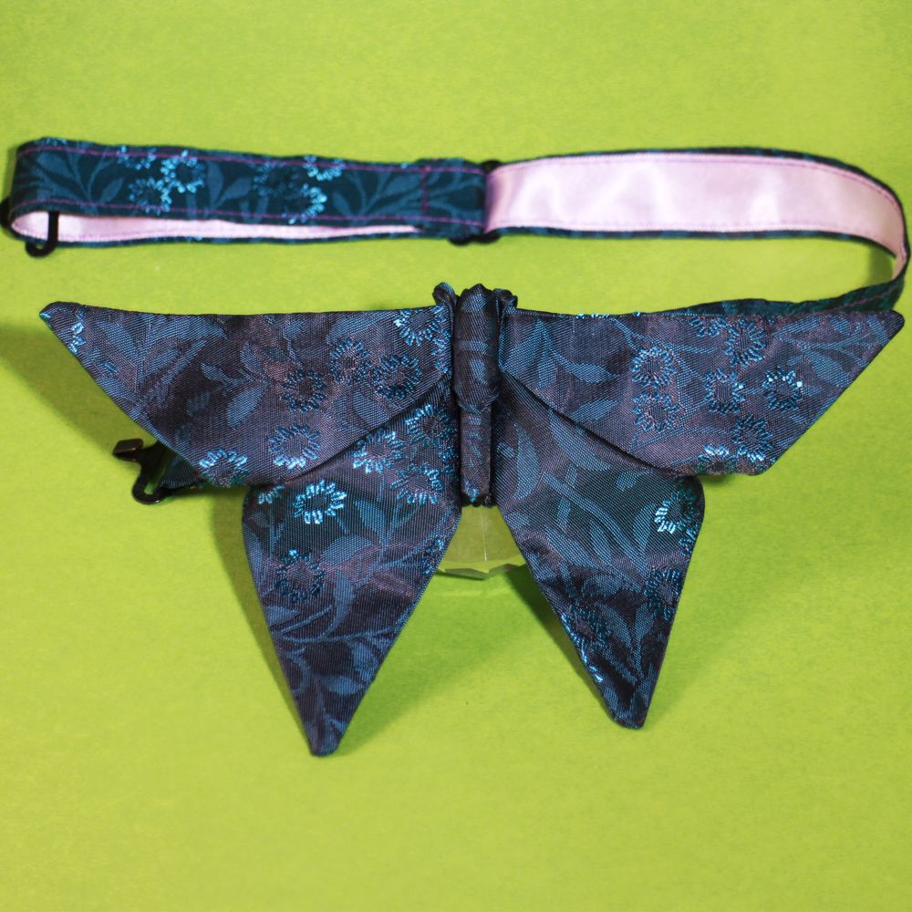 Detail of an origami butterfly bow tie with electric blue floral detail with satin ribbon showing