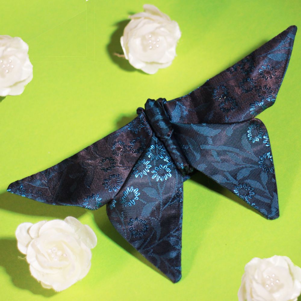 Detail of an origami butterfly bow tie with electric blue floral detail