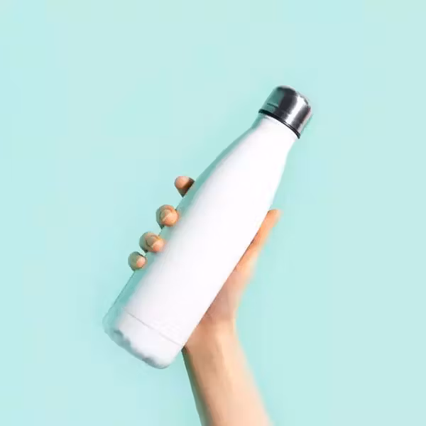  Hand holding water bottle against colorful background 